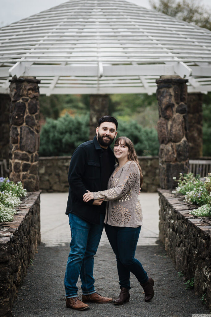 Engaged couple standing under white gazebo at Deep Cut Gardens Middletown NJ - Alex Kaplan Photography