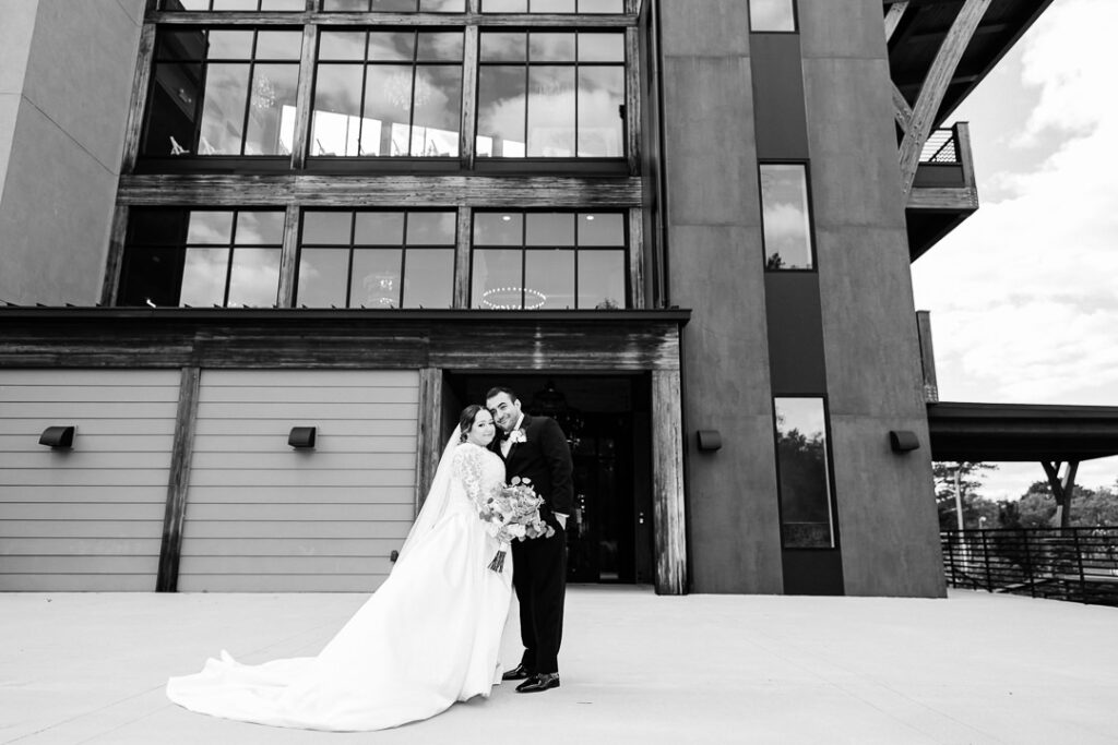Black-and-white of newlyweds walking hand in hand through Lincoln Park.