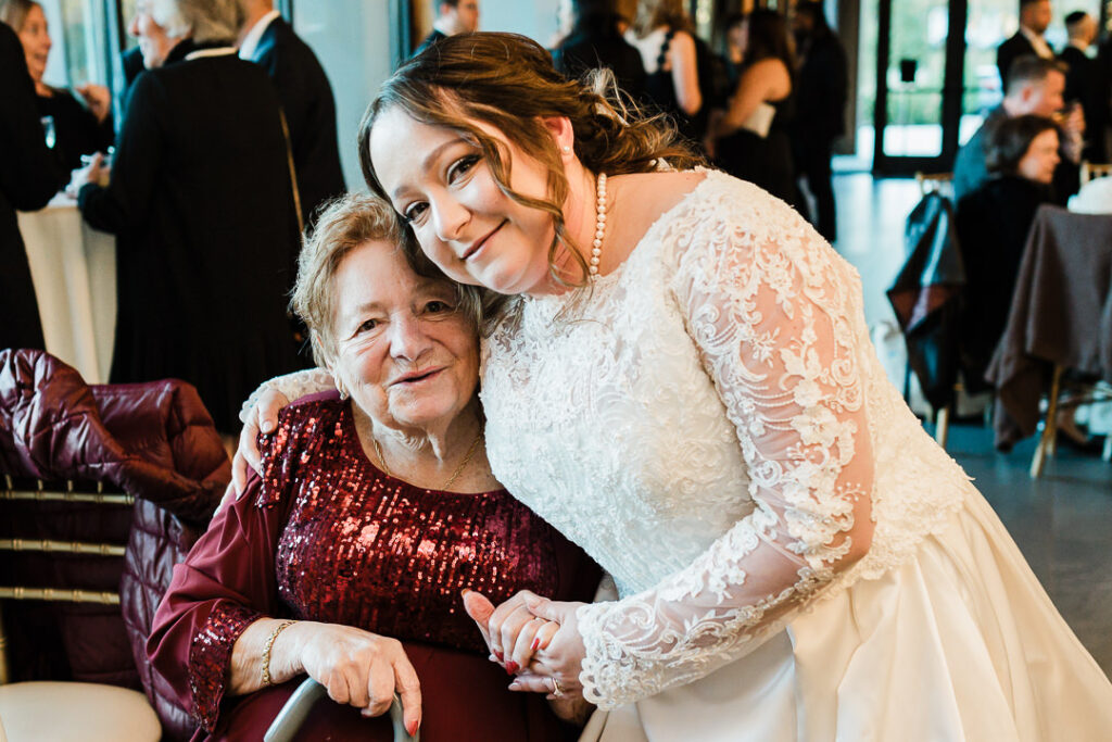 Emotional moment between bride and grandmother in burgundy sequin dress.