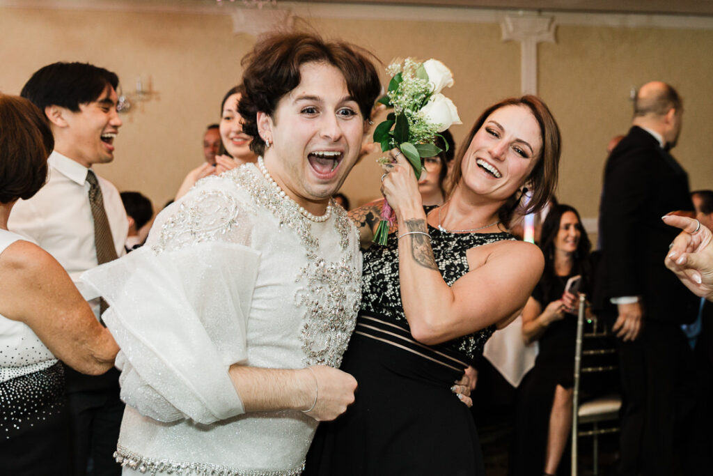 Guest celebrating after catching bouquet at Cortlandt Colonial reception Hudson Valley wedding