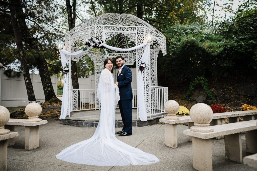 Color portrait of outdoor ceremony with gazebo and autumn trees Cortlandt Colonial wedding venue