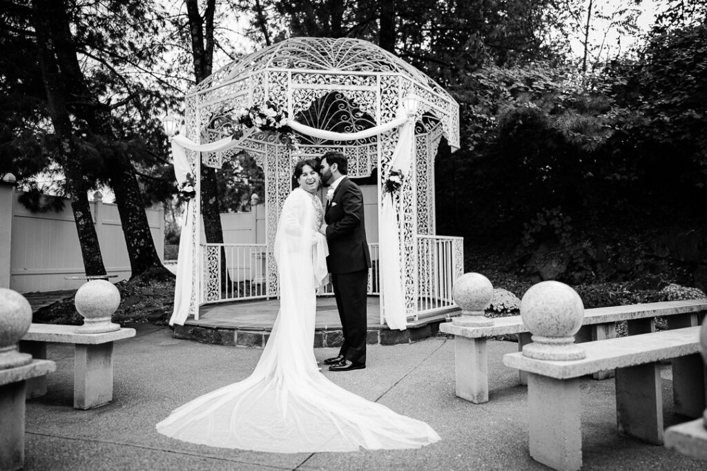 Black-and-white photo of couple at Victorian gazebo Cortlandt Manor NY evening wedding