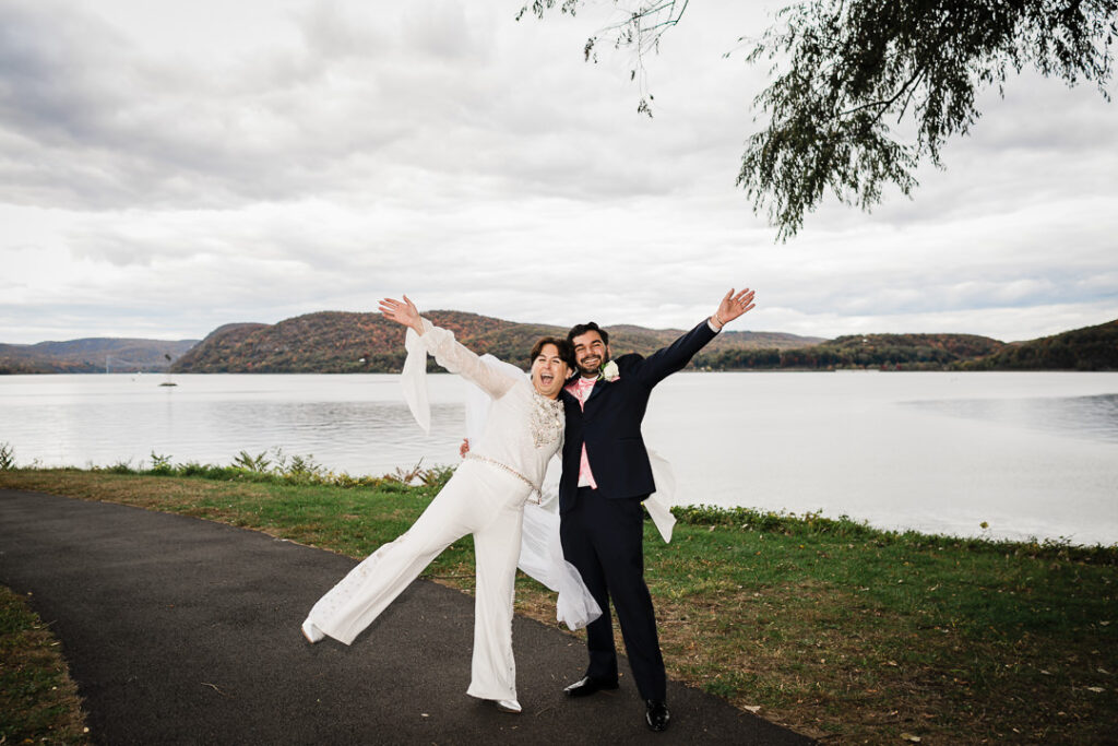 Couple embracing by waterfall feature at Cortlandt Colonial with fall foliage Hudson Valley venue