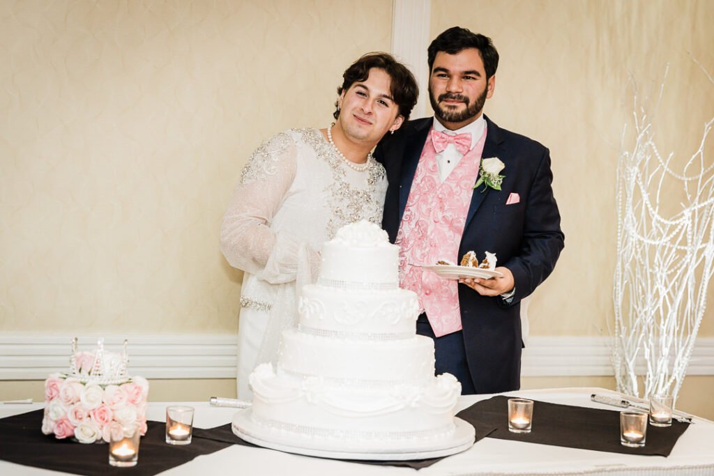 Playful cake moment with bride raising finger and groom laughing Cortlandt Colonial reception