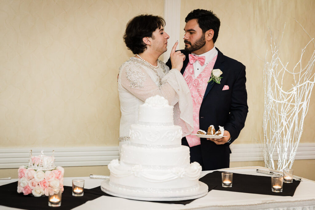 Couple sweetly feeding each other cake at Cortlandt Colonial ballroom reception Hudson Valley