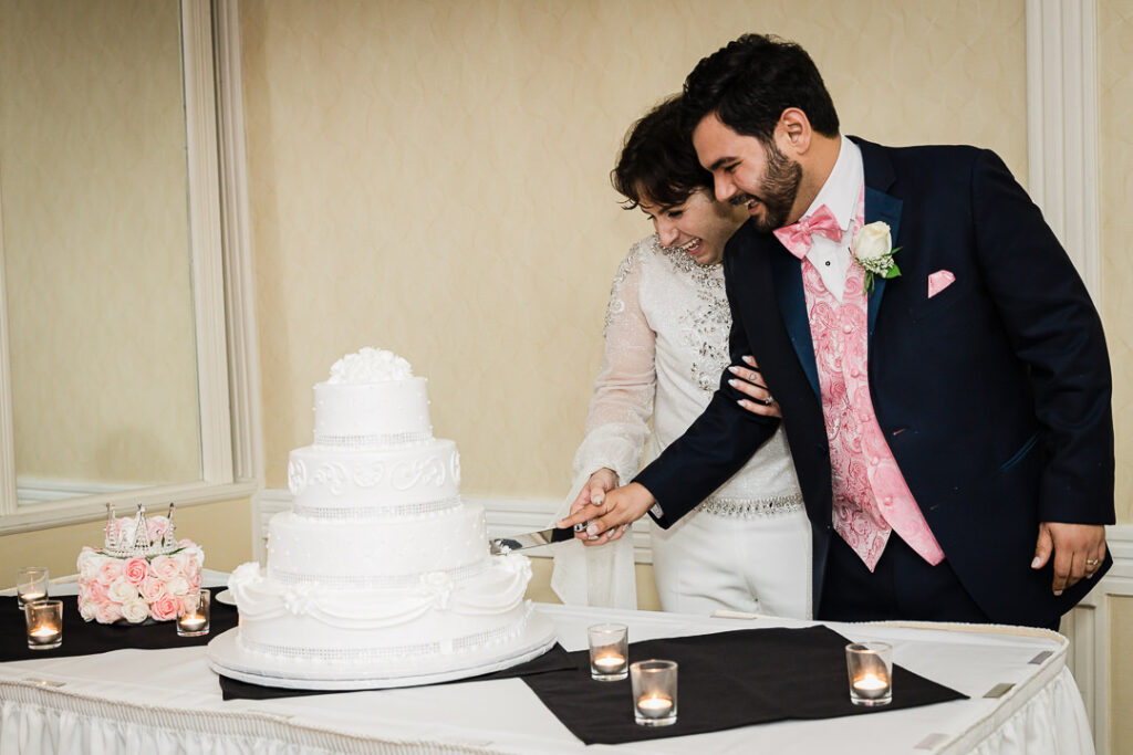 Traditional cake cutting with pearl and ruffle details Cortlandt Colonial ballroom wedding