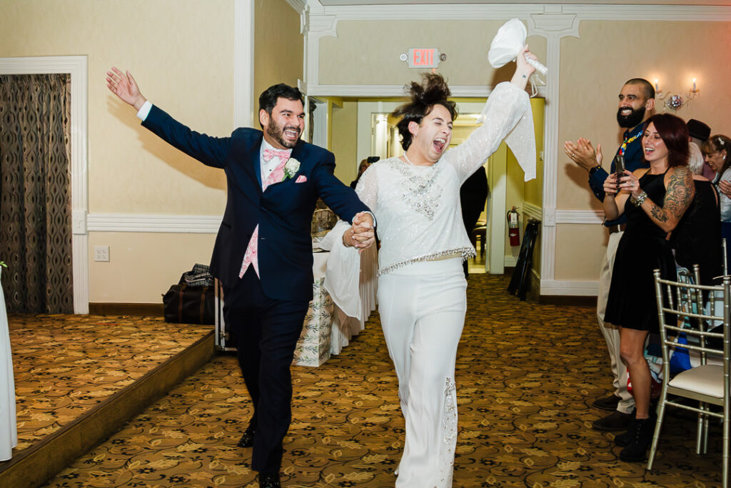 Couple making grand entrance into Cortlandt Colonial ballroom while guests cheer Hudson Valley wedding