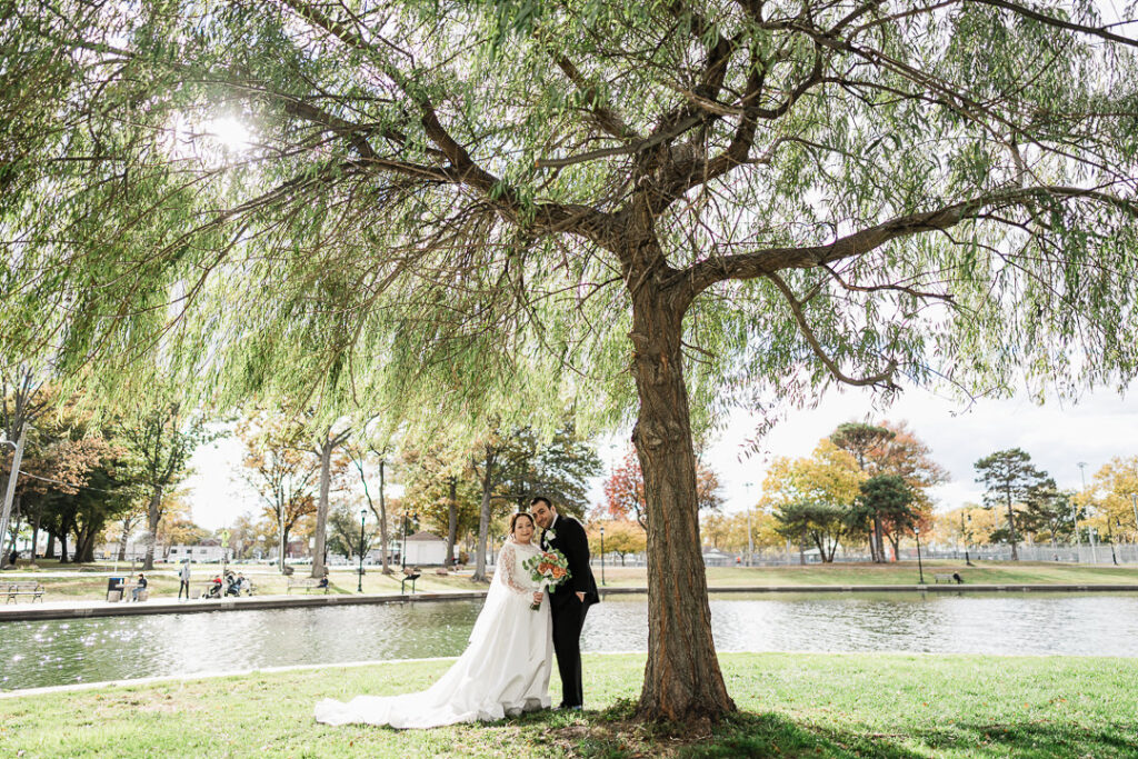 Golden-hour portrait under willow with sun flare in Lincoln Park.