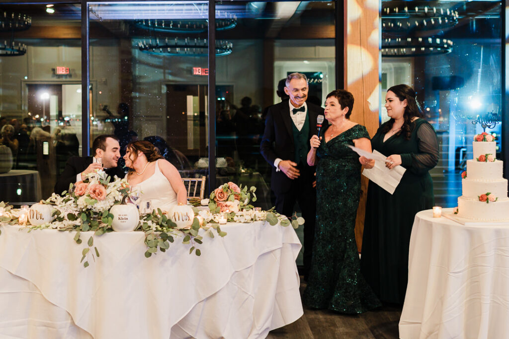 Parents giving emotional wedding speech toast at reception.