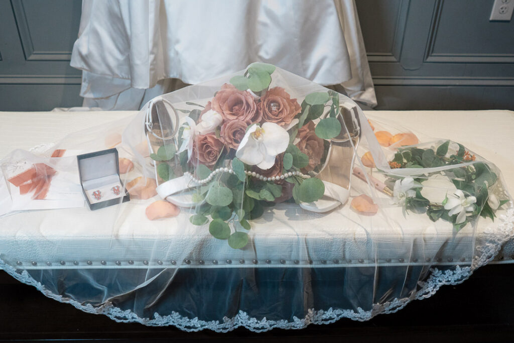 Bridal bouquet with white orchids, coral roses, and eucalyptus for Jersey City wedding.