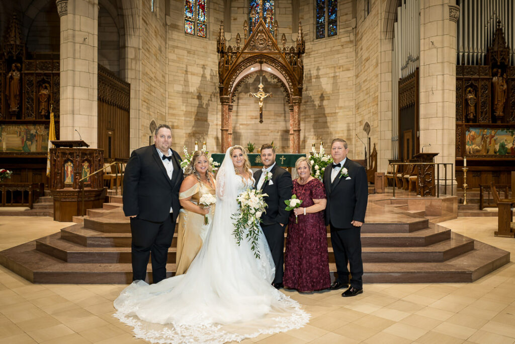 Bride with parents and family after wedding ceremony at Our Lady of Sorrows Catholic Church in South Orange NJ, photographed by Alex Kaplan Weddings.
