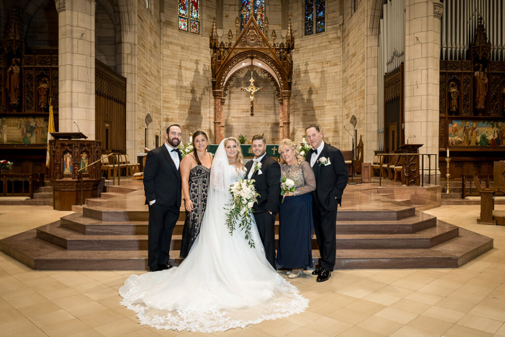 Groom with parents and family during wedding portraits inside Our Lady of Sorrows Catholic Church in South Orange NJ, captured by Alex Kaplan Weddings.