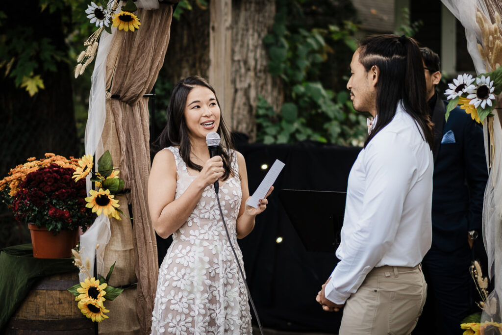 Bride reading personal vows during outdoor backyard wedding ceremony in NJ