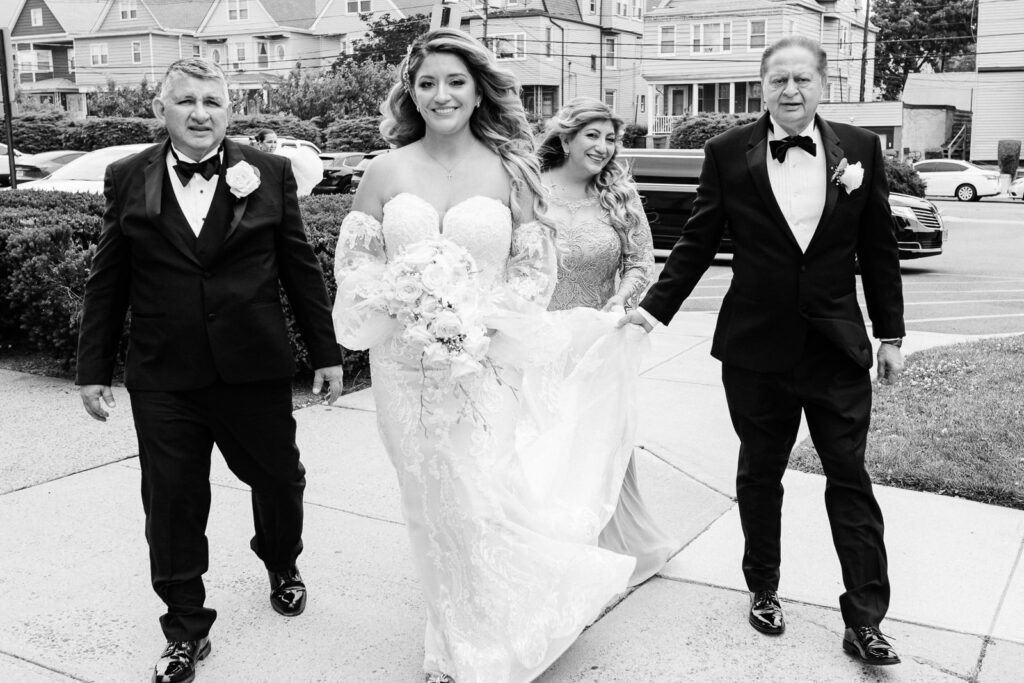 Bride walking with father stepfather and mother before church ceremony in blended family moment photographed by Alex Kaplan Photography