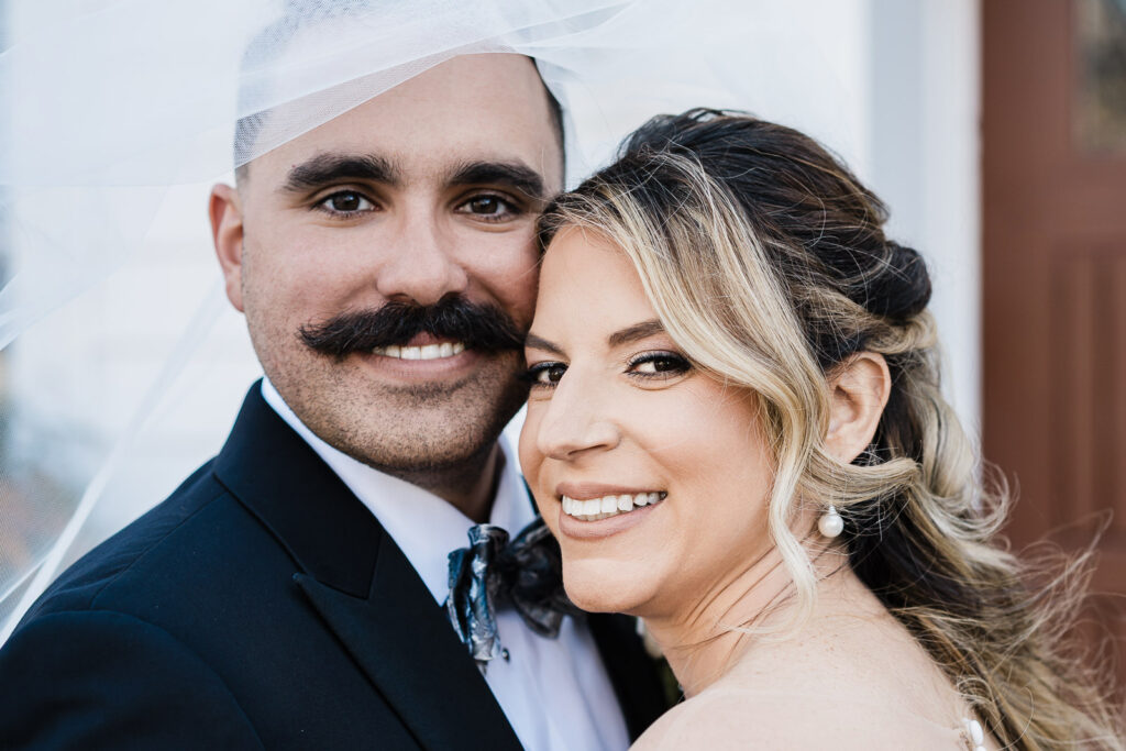 Close-up portrait of bride and groom with veil at The English Manor wedding