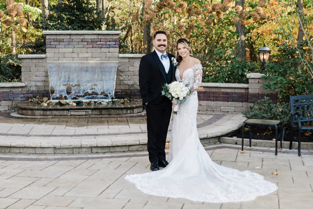 Bride and groom formal portrait at fountain with fall foliage at The English Manor Ocean Township