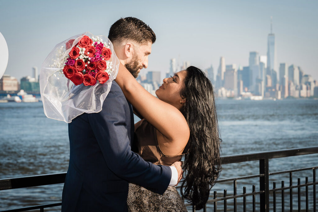 Engaged couple with roses at NYC waterfront engagement session by Alex Kaplan Photography