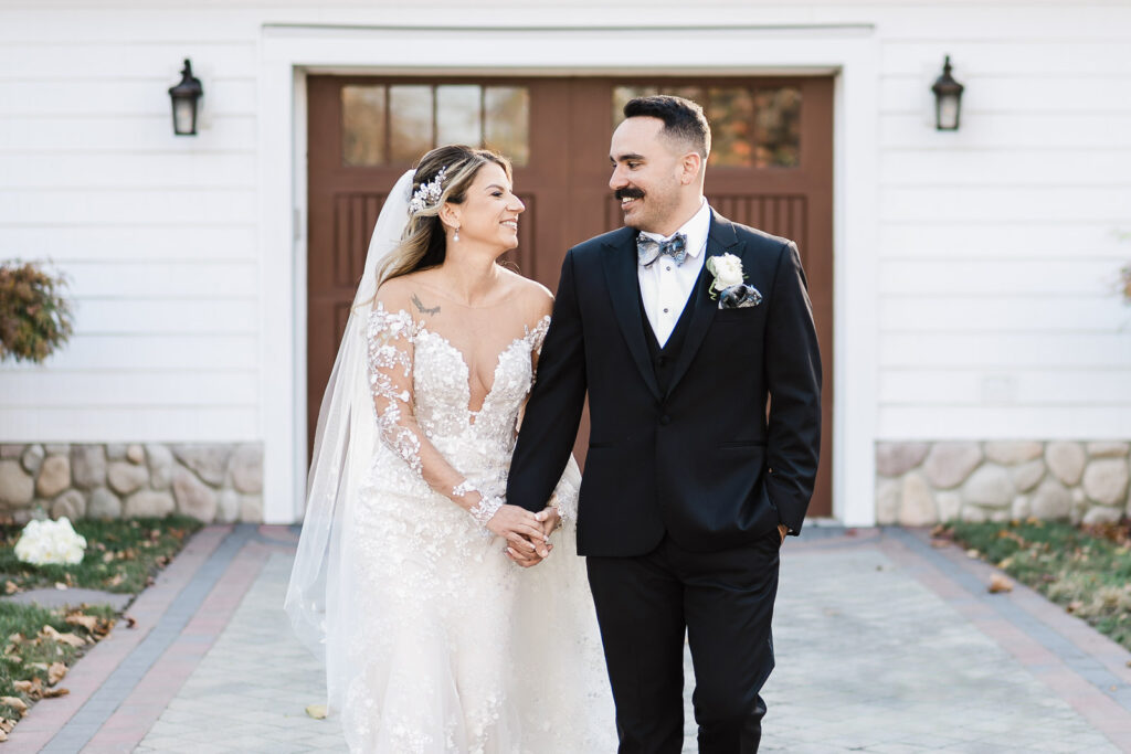 Bride and groom walking together on pathway at The English Manor fall wedding
