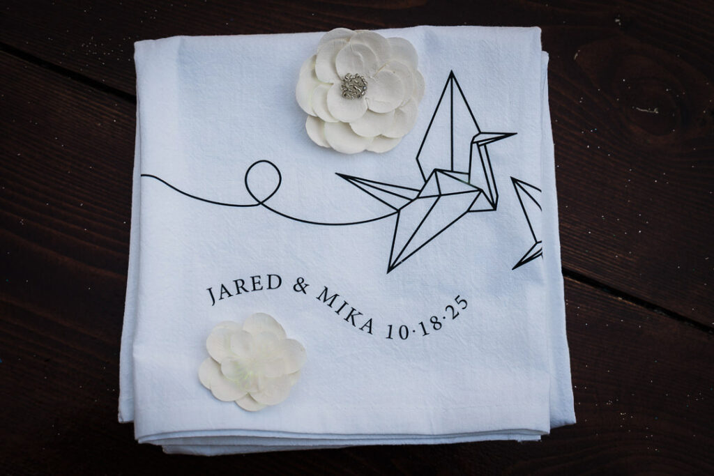 Personalized wedding napkin featuring origami crane design and wedding date