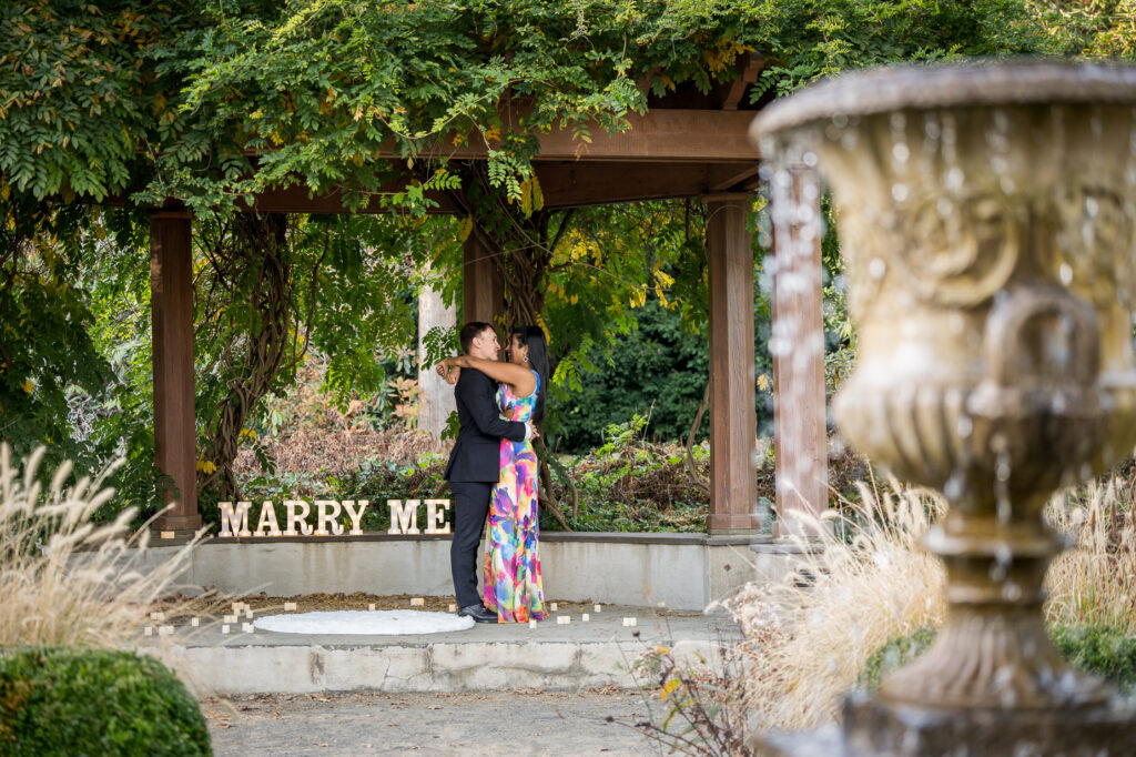 Engaged couple laughing together during fall botanical garden engagement portrait session