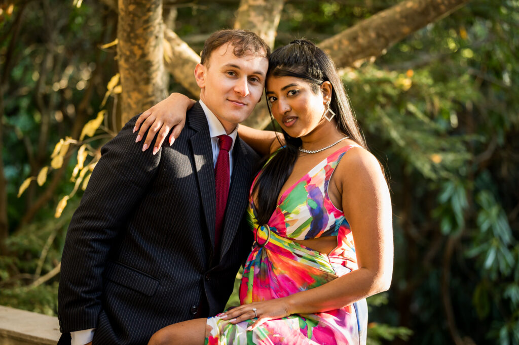 Engagement couple portrait with classical columns and wisteria vines at botanical garden