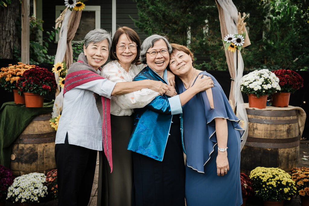Group of women posing together in front of wedding ceremony arch in NJ