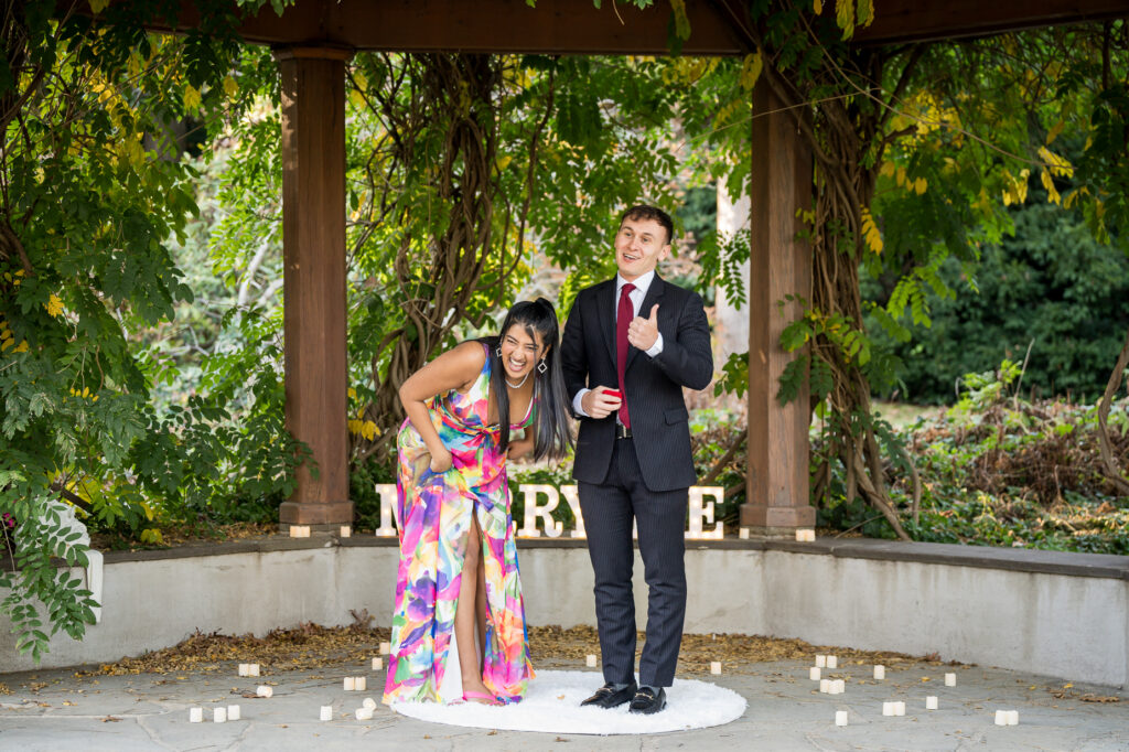 Romantic engagement kiss under pergola with soft natural autumn light in botanical garden