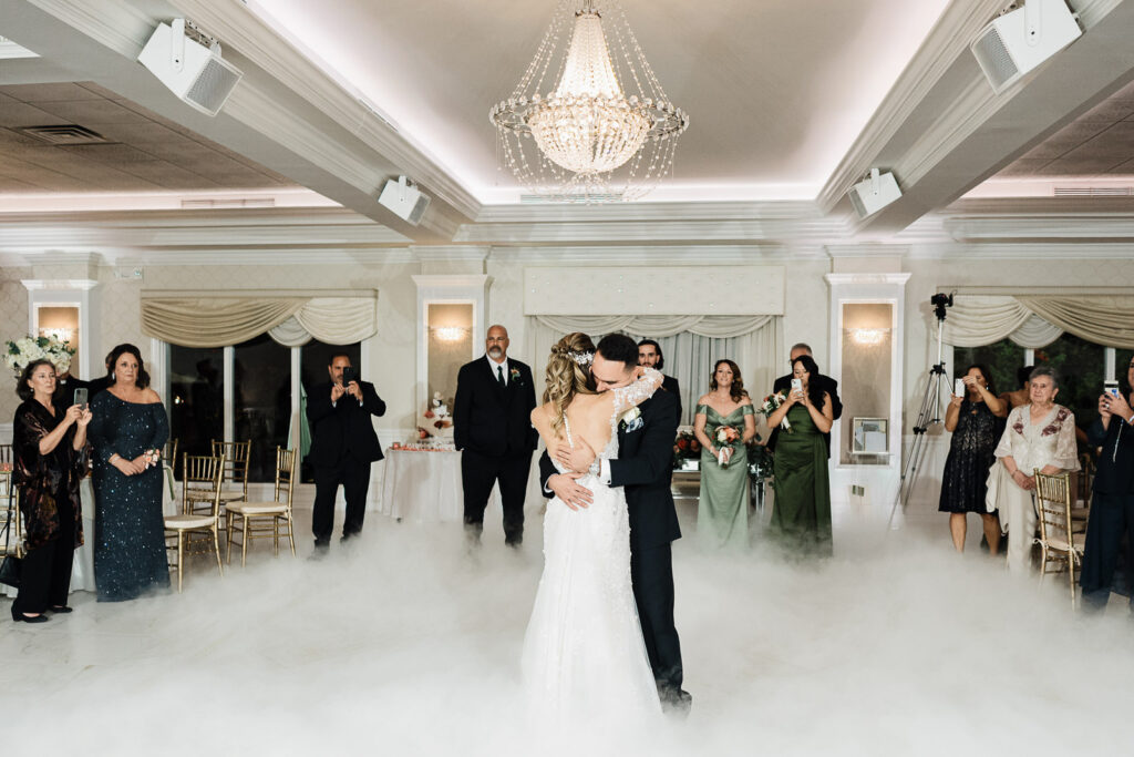 Groom carrying bride at bar during The English Manor wedding reception black and white
