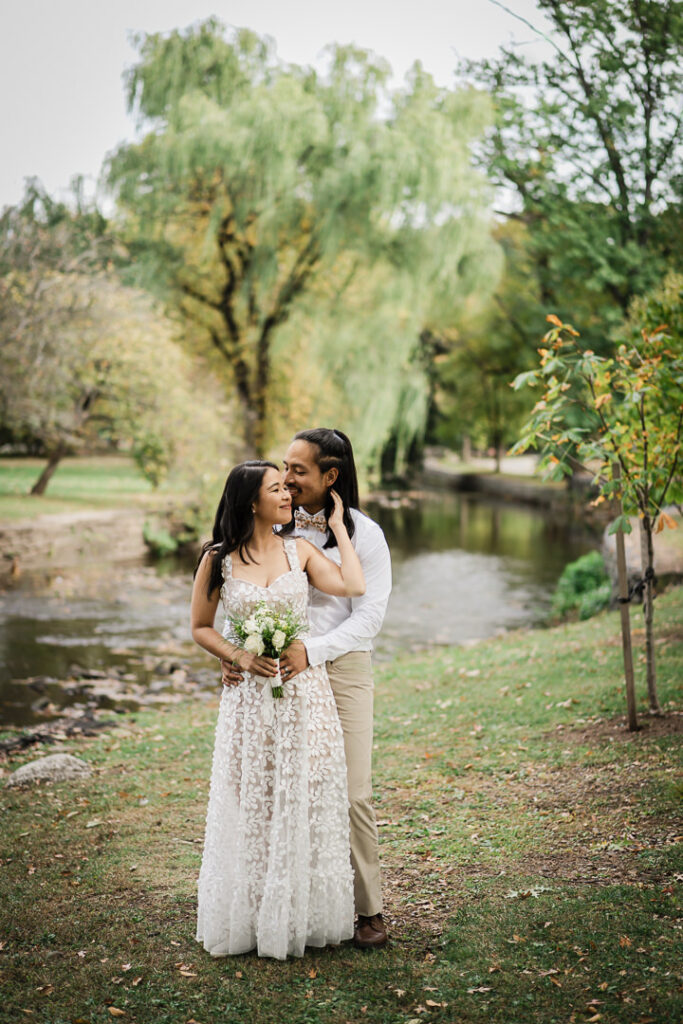 Couple walking under golden fall trees at Kingsland Park in Nutley, NJ