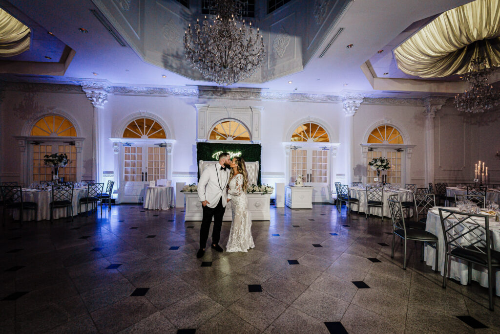 Couple portrait in Legacy Castle grand ballroom with chandeliers by Alex Kaplan Photography