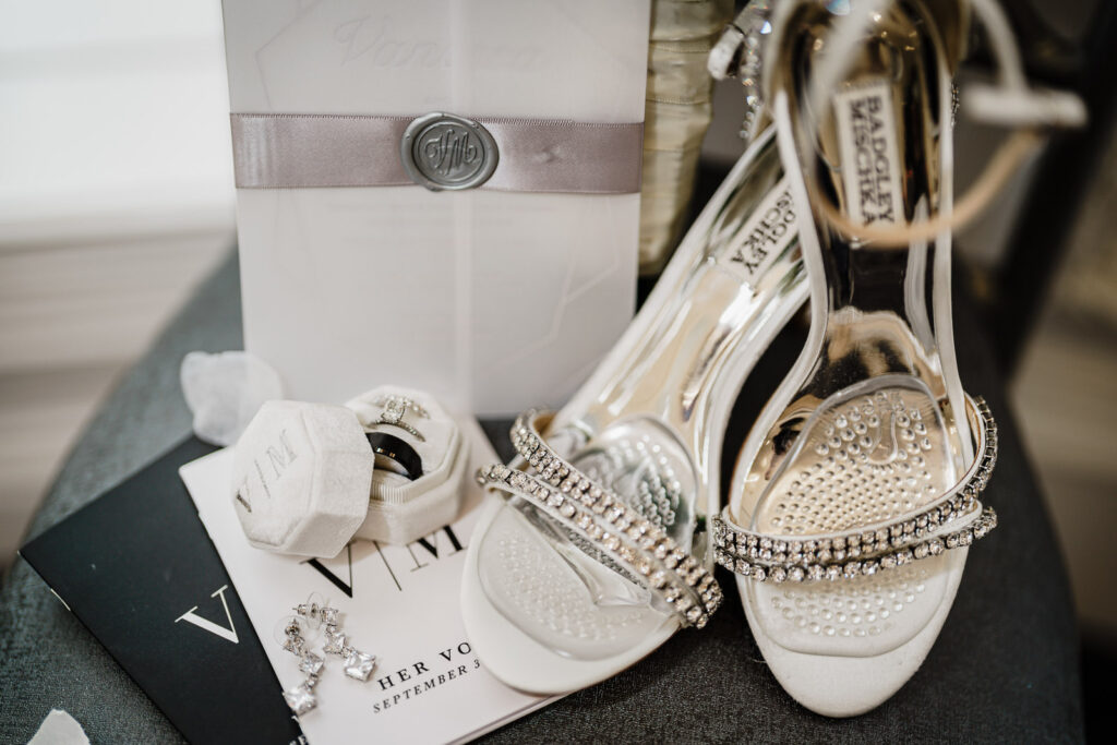 Wedding detail shot with bridal shoes and invitation at The Legacy Castle by Alex Kaplan