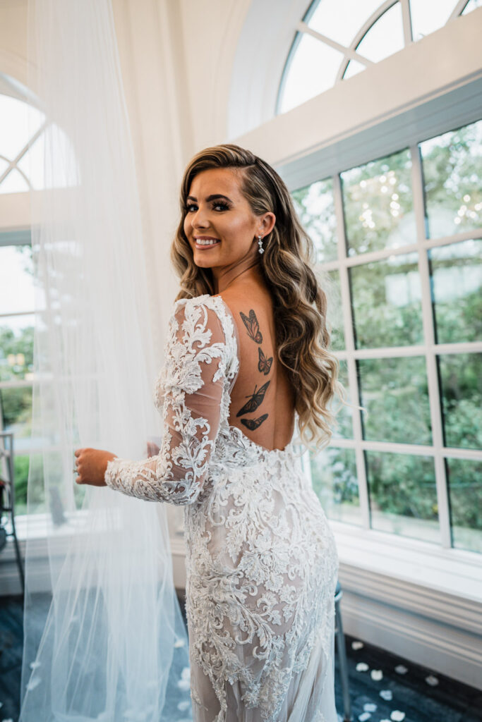 Bride showing dress back detail at Legacy Castle bridal suite by Alex Kaplan