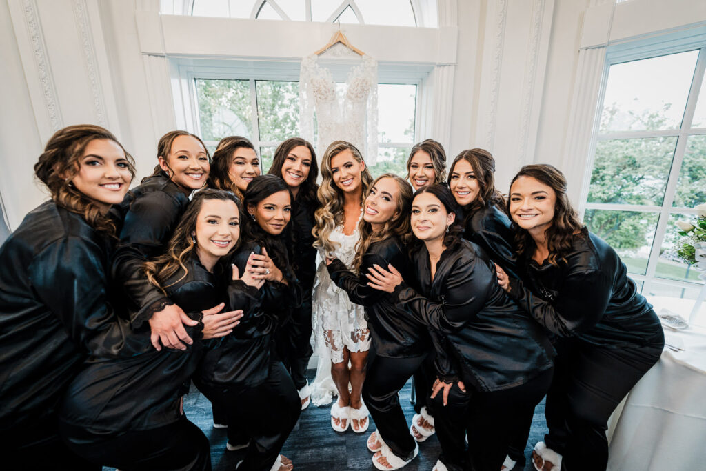 Bride with bridesmaids in black satin robes at Legacy Castle bridal suite by Alex Kaplan
