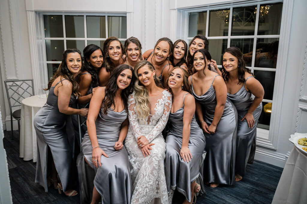 Bride with bridesmaids in charcoal gowns at Legacy Castle Pompton Plains NJ by Alex Kaplan