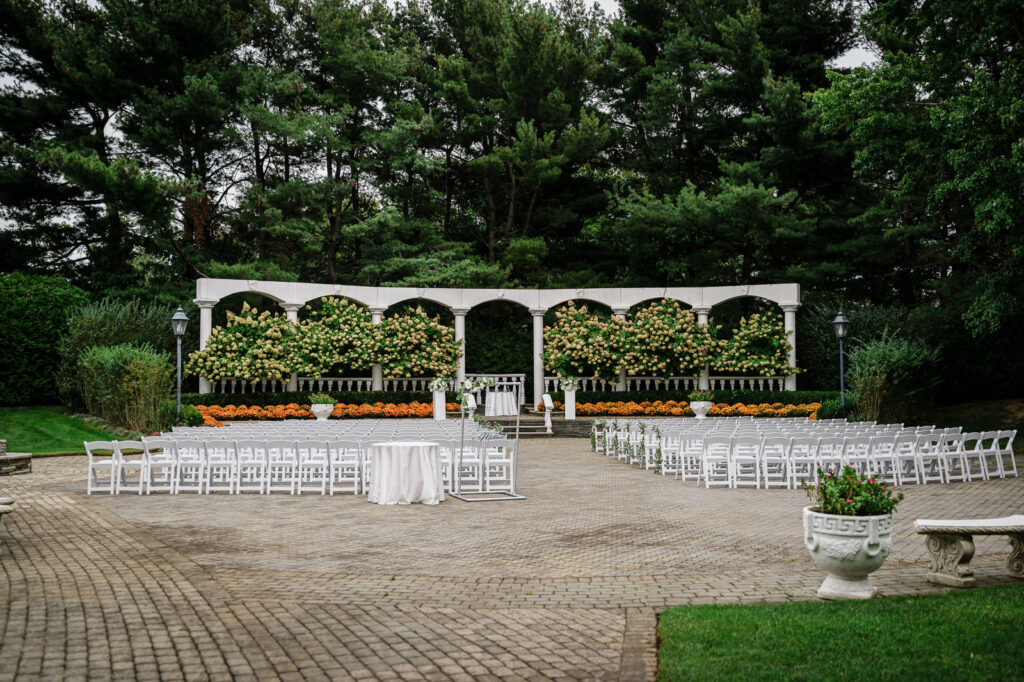 Outdoor ceremony space with white colonnade at The Legacy Castle Pompton Plains by Alex Kaplan