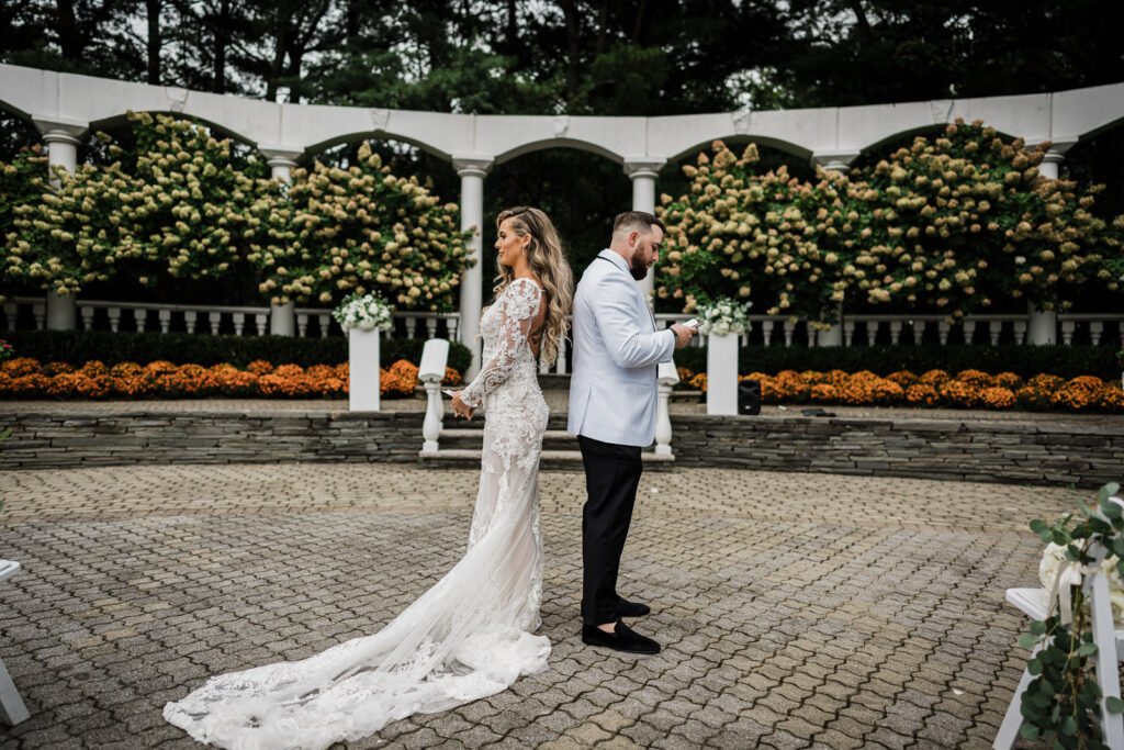 Couple holding hands during first look at Legacy Castle wedding by Alex Kaplan