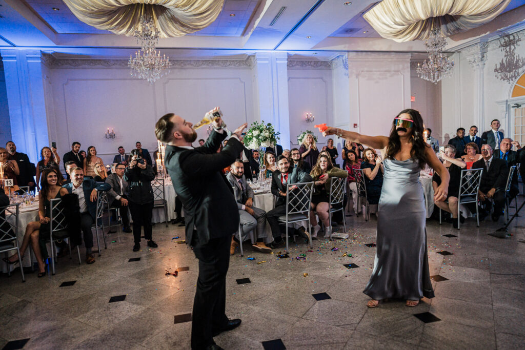 Groomsmen celebrating with drinks at Legacy Castle wedding reception by Alex Kaplan Photography