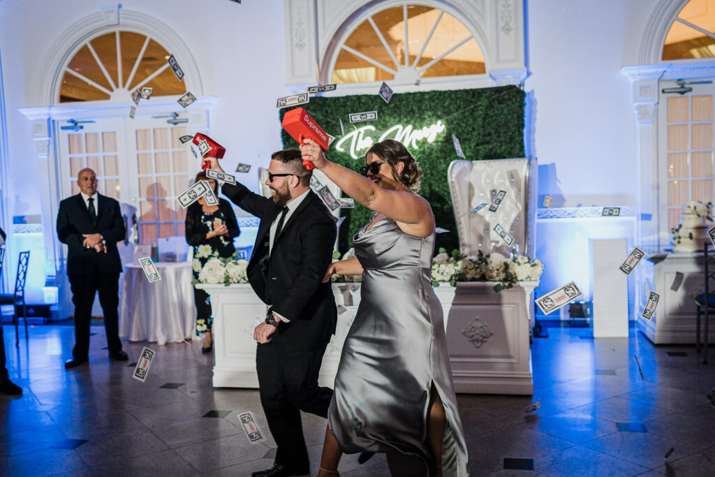 Money gun celebration during hora at The Legacy Castle wedding by Alex Kaplan