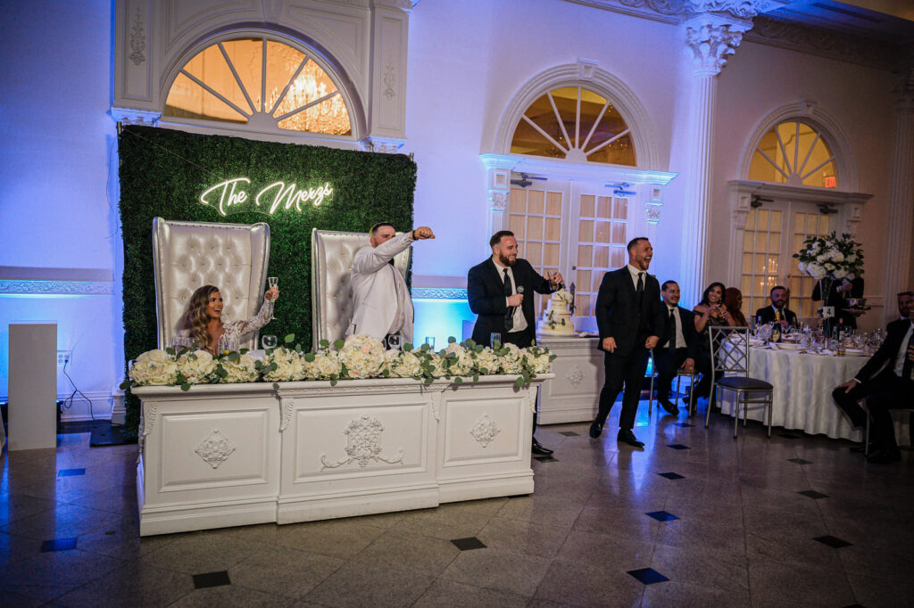 Bridesmaids giving toasts at sweetheart table at The Legacy Castle wedding by Alex Kaplan