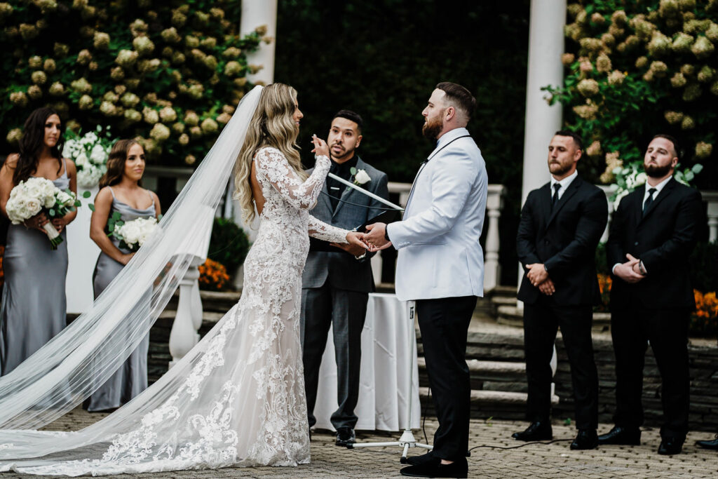 Couple exchanging vows during outdoor ceremony at The Legacy Castle wedding photographed by Alex Kaplan