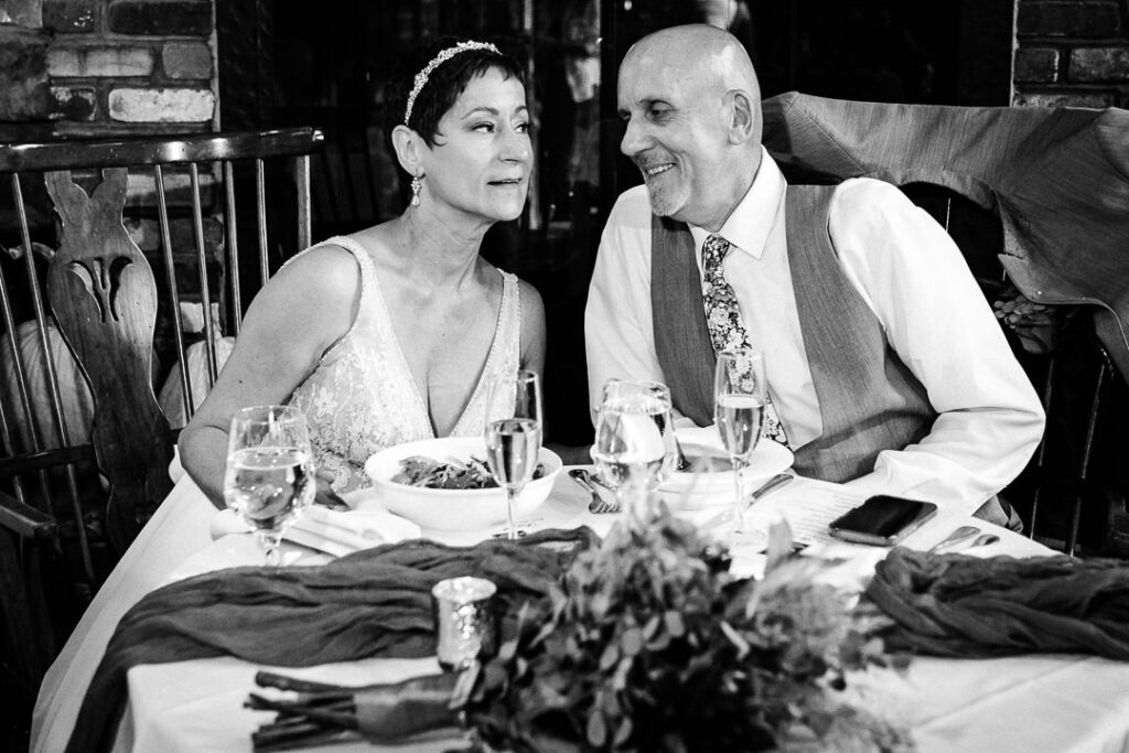 Candid moment of couple at sweetheart table during Mohawk House reception in Sparta New Jersey by Alex Kaplan