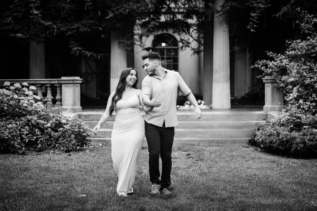 Alex Kaplan Photography captures engaged couple walking hand in hand through formal gardens in Northern New Jersey