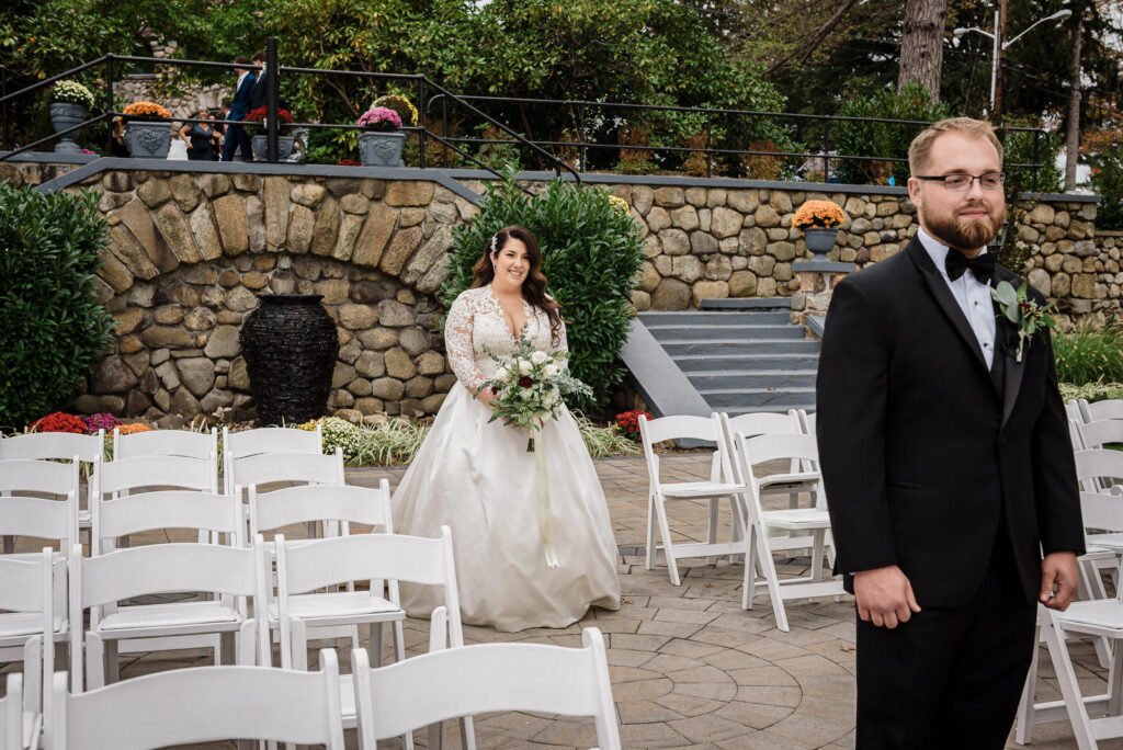 Bride approaching groom for first look at Ramsey Country Club outdoor ceremony by Alex Kaplan Photography