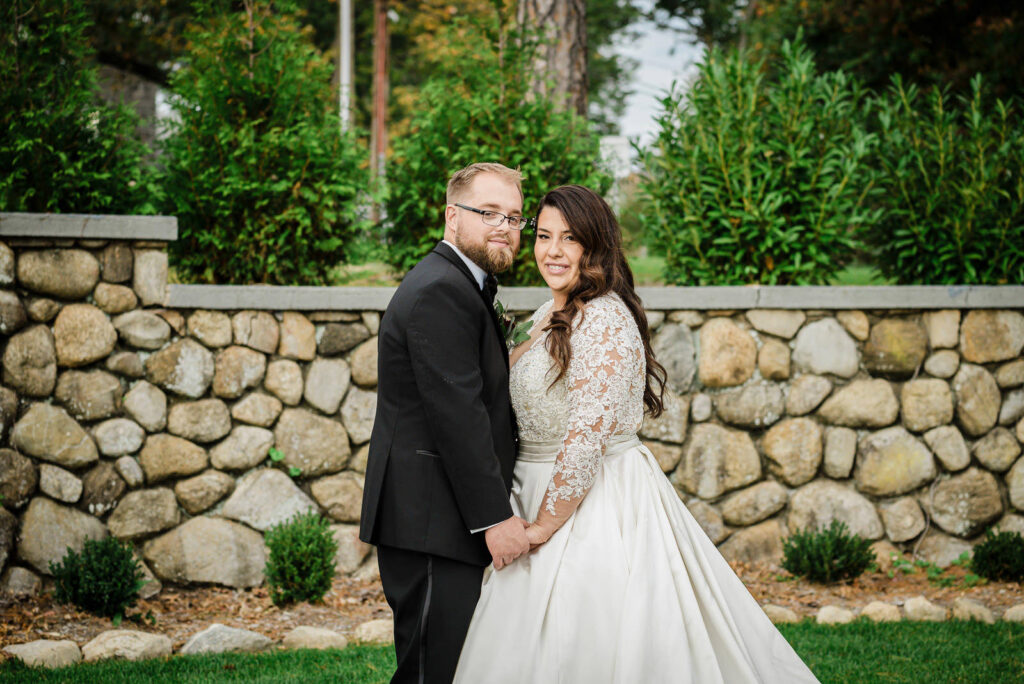 Formal bride and groom portrait against stone wall at Ramsey Country Club photographed by Alex Kaplan Photography
