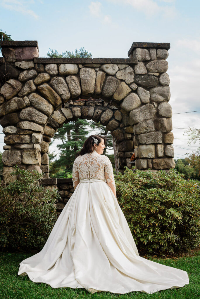 Bride under historic stone archway at Ramsey Country Club wedding photographed by Alex Kaplan Photography