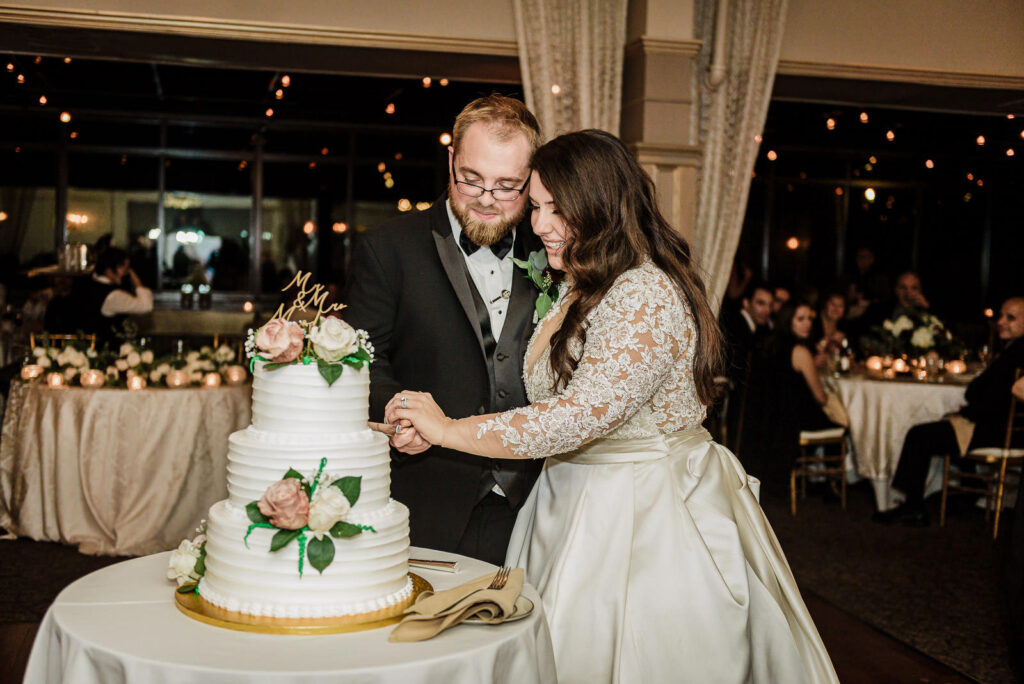 Couple cutting three tier wedding cake at Ramsey Country Club Alex Kaplan