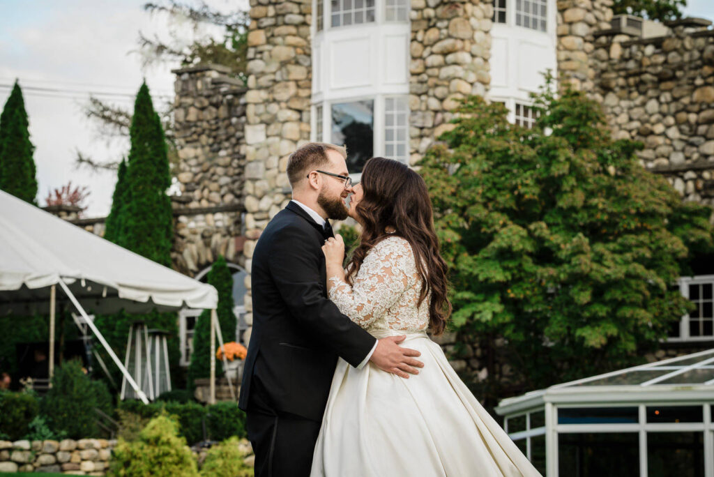 Romantic evening kiss at Abbey entrance Ramsey Country Club fall wedding by Alex Kaplan Photography