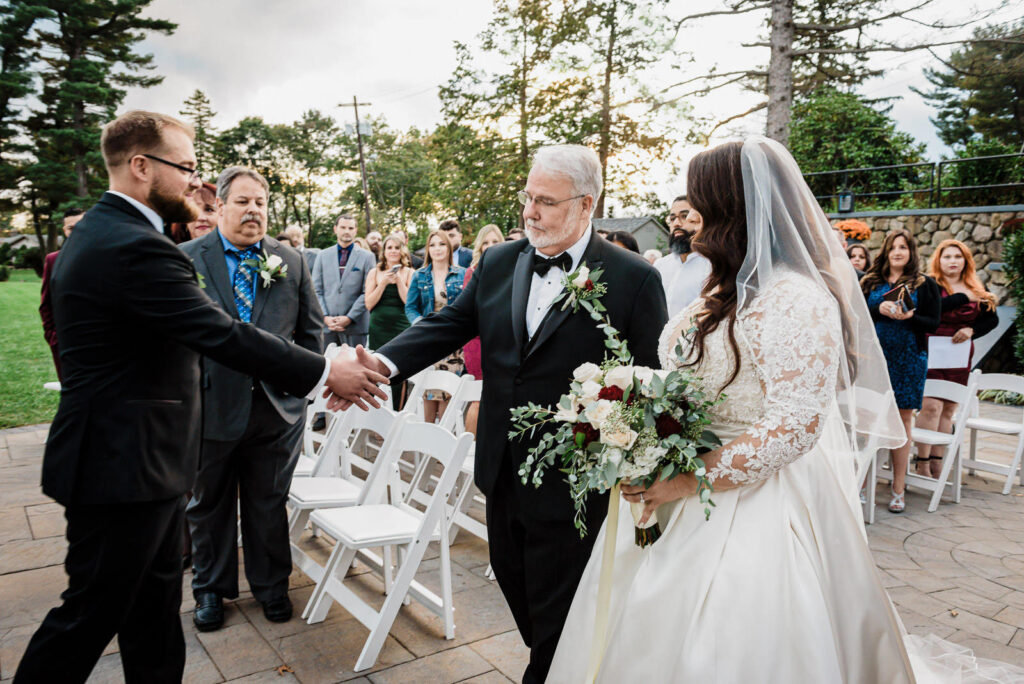 Father handing bride to groom at outdoor ceremony Ramsey Country Club by Alex Kaplan