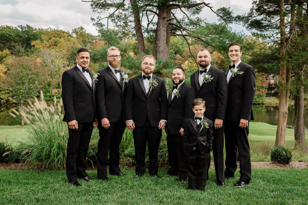  Groomsmen in black tuxedos with ring bearer at Ramsey Country Club wedding photographed by Alex Kaplan