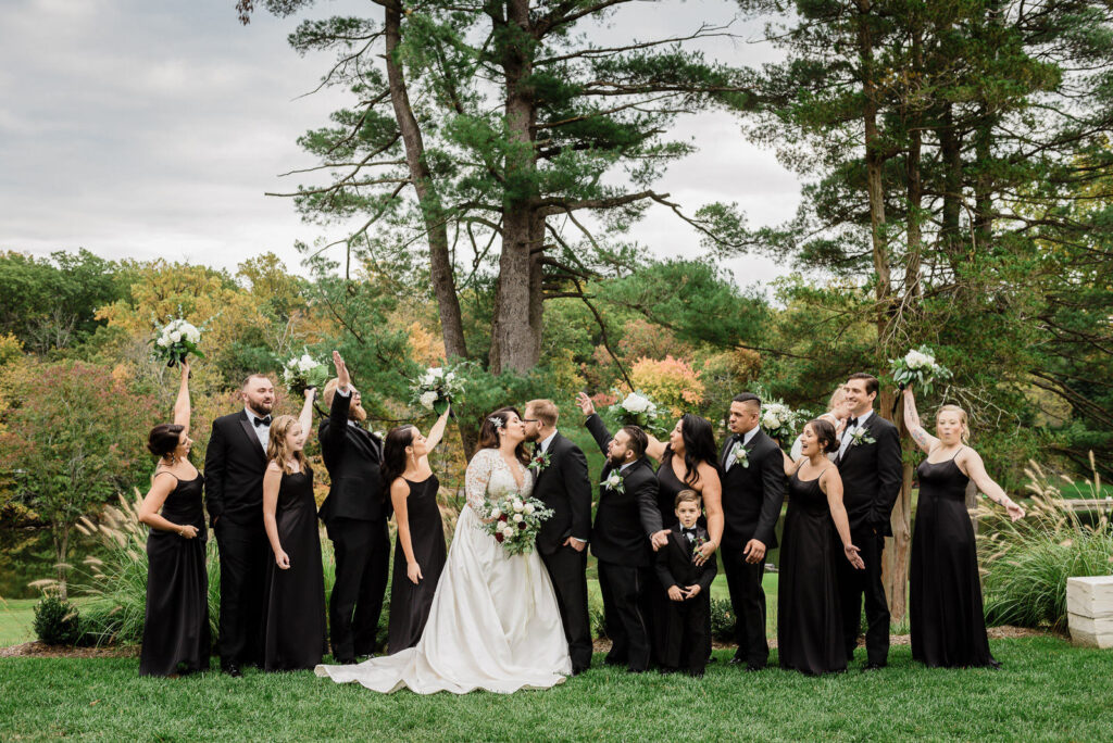Wedding party cheering with bouquets raised at Ramsey Country Club fall wedding by Alex Kaplan Photography
